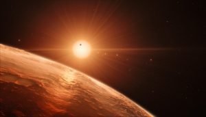 This artist’s impression shows the view from the surface of one of the planets in the TRAPPIST-1 system. At least seven planets orbit this ultra cool dwarf star 40 light-years from Earth and they are all roughly the same size as the Earth. They are at the right distances from their star for liquid water to exist on the surfaces of several of them. This artist’s impression is based on the known physical parameters for the planets and stars seen, and uses a vast database of objects in the Universe.